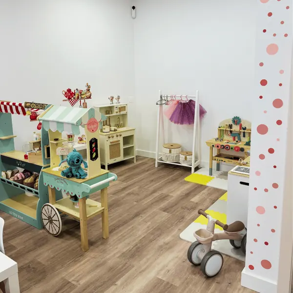 Área da mercearia de madeira e triciclo, com parede decorada