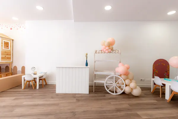 Carrinho decorado com balões cor de rosa junto ao balcão de apoio